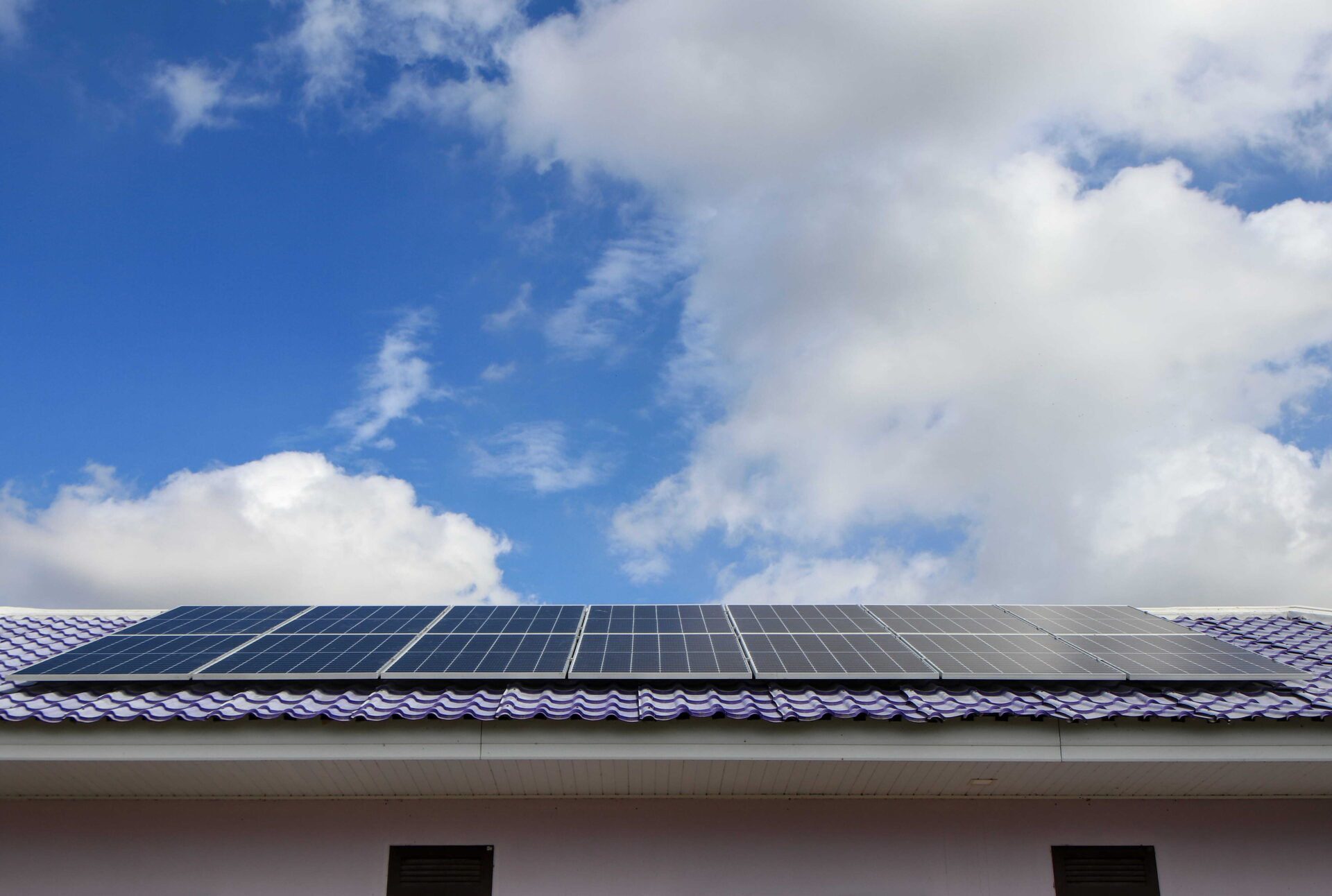 Solar Panels on a Tiled Roof Against a Blue Sky